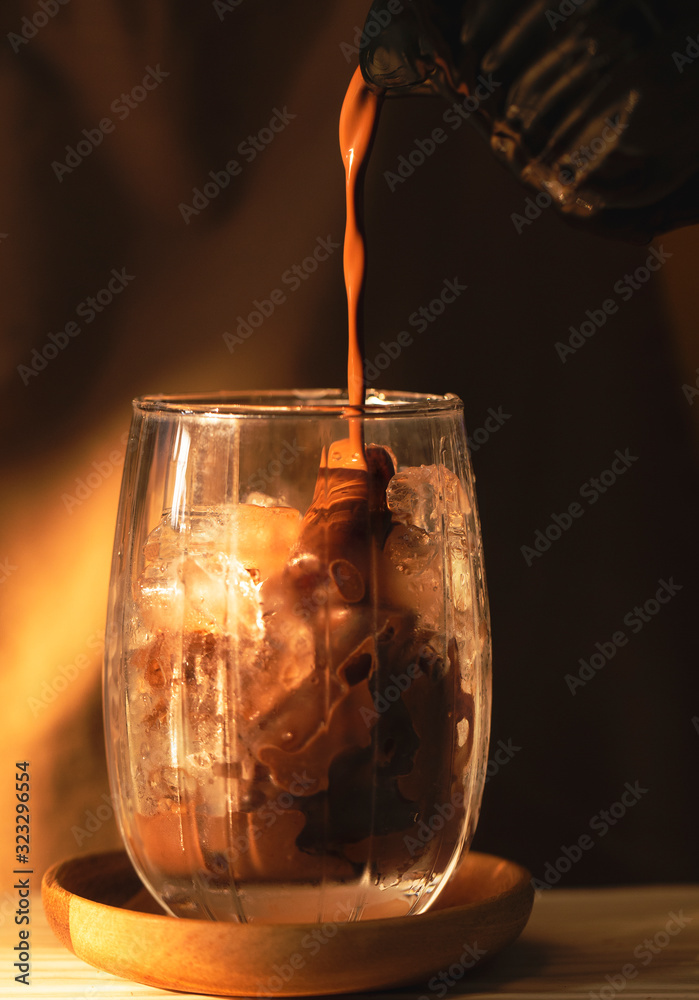 Cocoa is pouring into a glass with ice. Cocoa is pouring into a glass with ice.