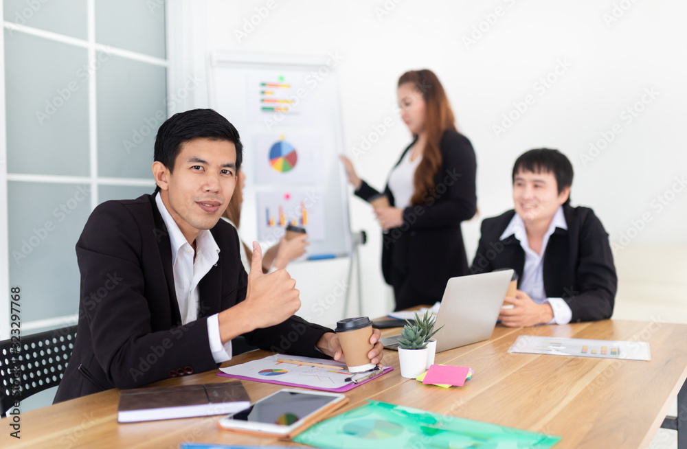 smart asian man officer typing report with laptop, he prepare information to executive conference and show thumb up sign, leadership and organization management, asian officer team discuss together smart asian man officer typing report with laptop, he prepare information to executive conference and show thumb up sign, leadership and organization management, asian officer team discuss together