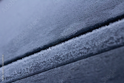 Frost in frosty weather on a black metal surface.