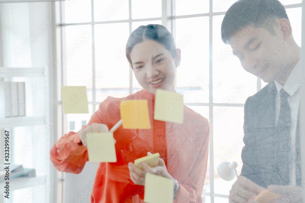 Business people writing ideas on sticky notes