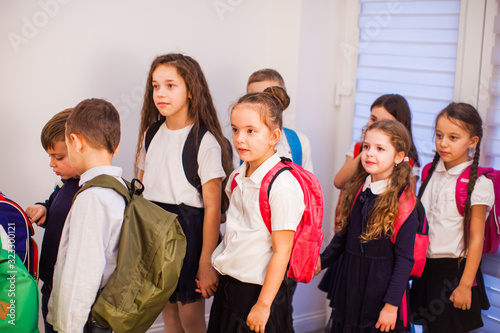 School children in uniform with backpacks going to class