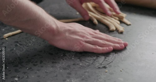 Slow motion man making grissini on concretre countertop photo