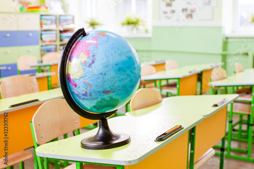 Earth globe on the yellow desk at classroom photo