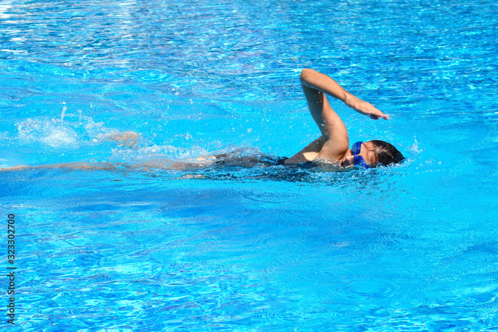 Female swimmer in pool. swimming training. Swimming in the outdoor pool. A healthy lifestyle at the resort.