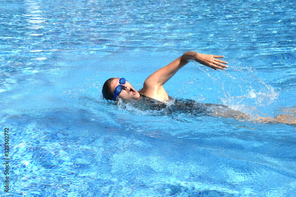 Female swimmer in pool. swimming training. Swimming in the outdoor pool. A healthy lifestyle at the resort.