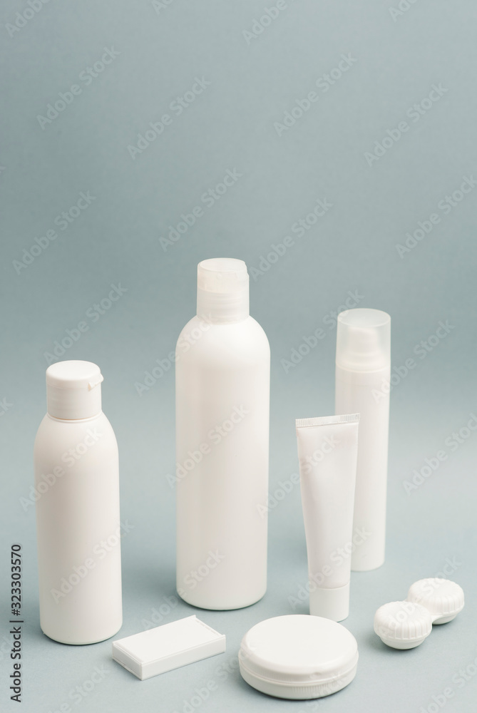 Collection of various beauty hygiene containers on soft gray background.