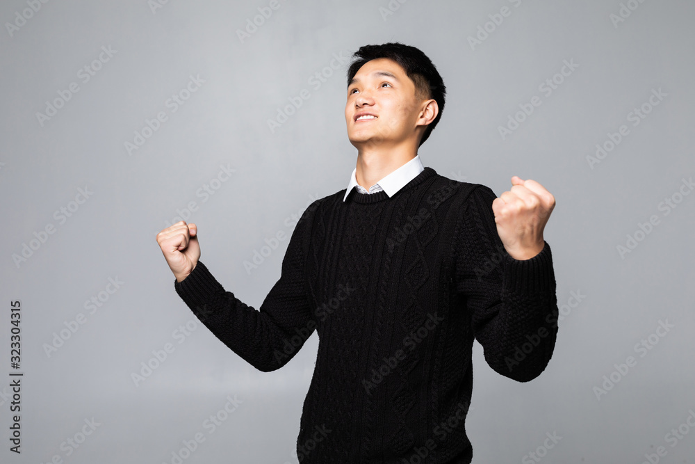 Young chinese man winner isolated on white background