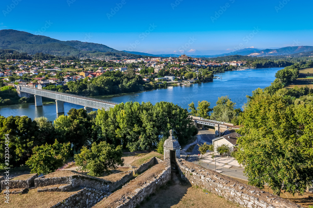 Landscape from Valença overlooking the border river with Spain. Iron bridge connecting Portugal to Spain, view from Tui, Spanish city near Portugal.
