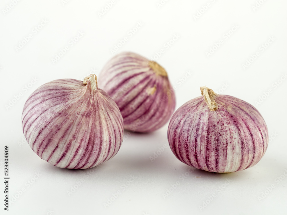 Fototapeta premium Fresh garlic on market table closeup photo. Vitamin healthy food spice image. Spicy cooking ingredient picture.