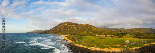 Panorama of Koko Head crater taken from a drone in Hawaii with both a rocky and a sandy beach with the incoming surf from the Pacific Ocean in morning light. photo