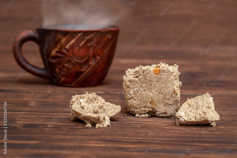 Cup of hot coffee and halva on a wooden table_