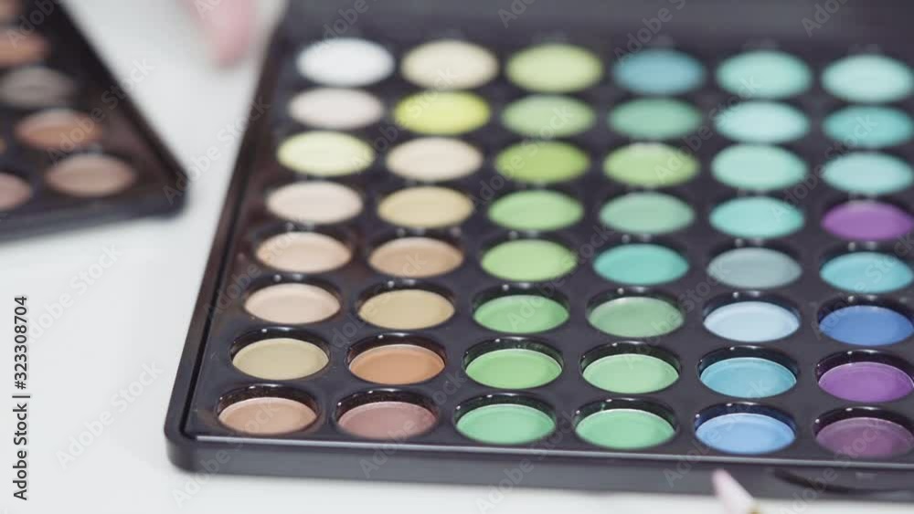 Unicorn-themed makeup brushes and eyeshadows palette on a white background. Unicorn-themed makeup brushes and eyeshadows palette on a white background.