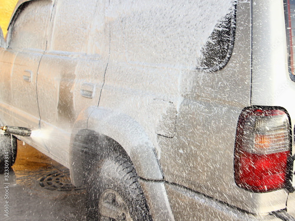 Vehicle body side touchless foamy spray washing, gray 4x4 truck cleaning with a high-pressure foam gun washer