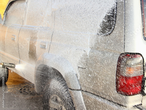 Vehicle body side touchless foamy spray washing, gray 4x4 truck cleaning with a high-pressure foam gun washer