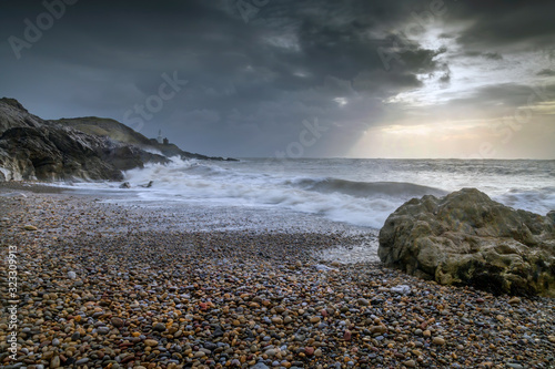 The dramatic clouds of Storm Ciara approach the rocky coastline of Bracelet Bay on the Gower peninsula in Swansea, South Wales, UK