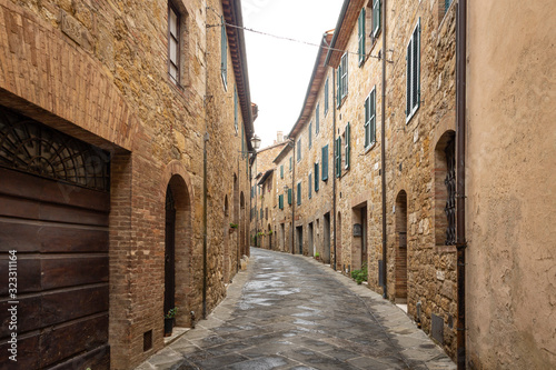 a street with typical houses in San Quirico d'Orcia, Province of Siena, Tuscany, Italy