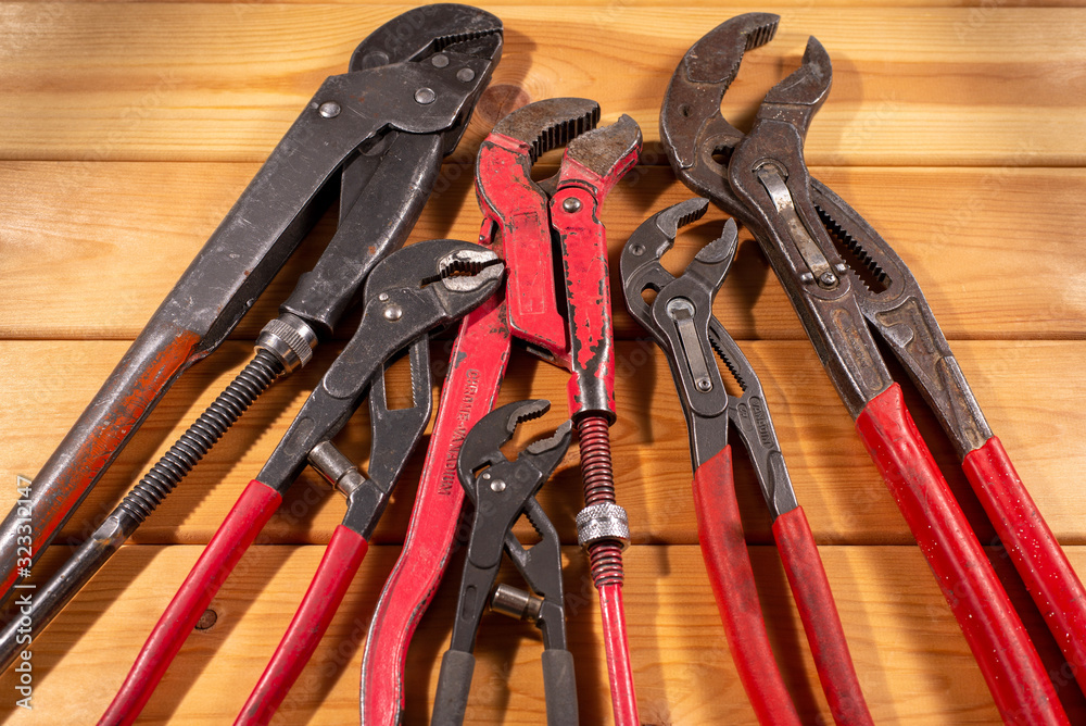 used plumber tools on wood plank background used plumber tools on wood plank background
