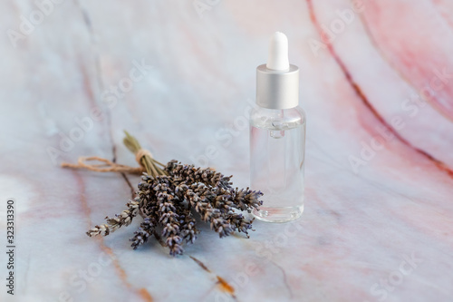 Lavender oil bottle on marble background.Essential oil  natural remedies. Lavander spa setting  Herbal oil and dried flowers natural spa products and decor for bath.Bottle with aroma oil