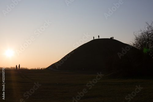 People silhouetted against the sky  watching the sun set from a hill in Krakow  Poland