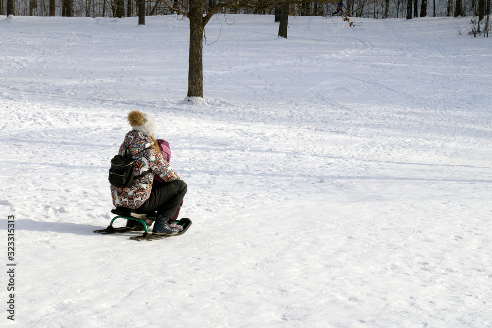 children ride a sled from a hill