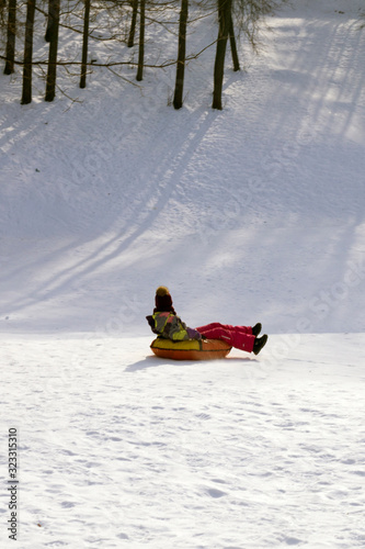 girl riding a tubing from a snow slide