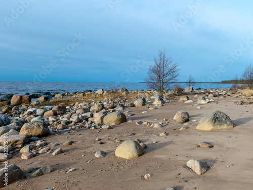 landscape with stony beach and lonely man silhouette in the evening