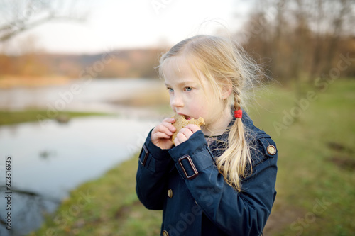 Cute young girl having fun on beautiful spring day. Active family leisure with kids.