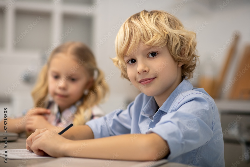 Two kids sitting at the table and looking cute