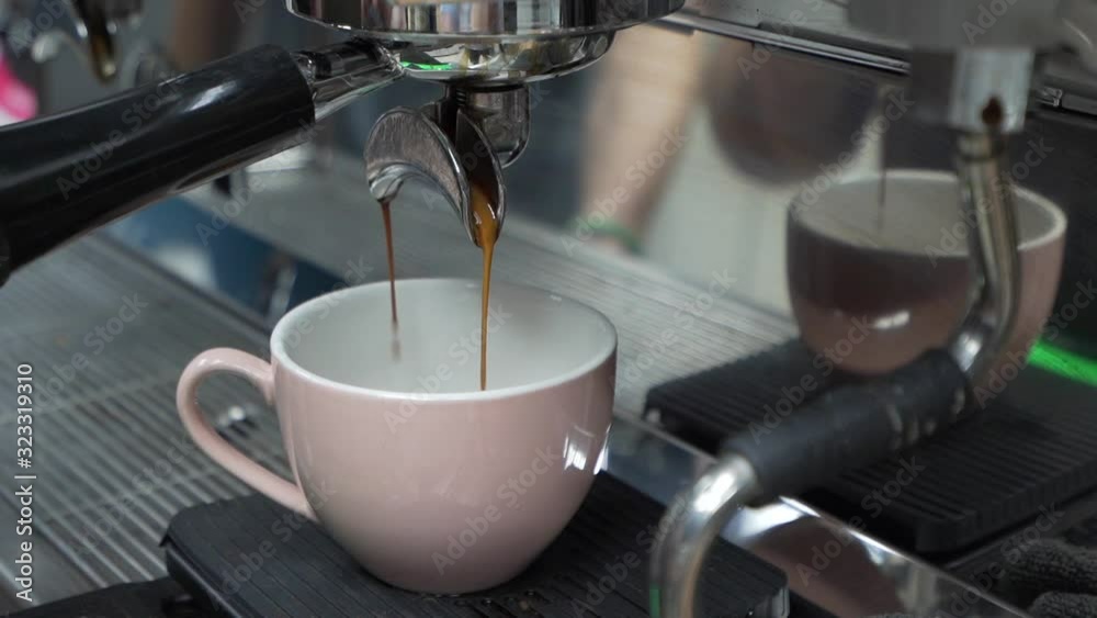 Coffee from a coffee machine pouring into a white mug, closeup Coffee from a coffee machine pouring into a white mug, closeup