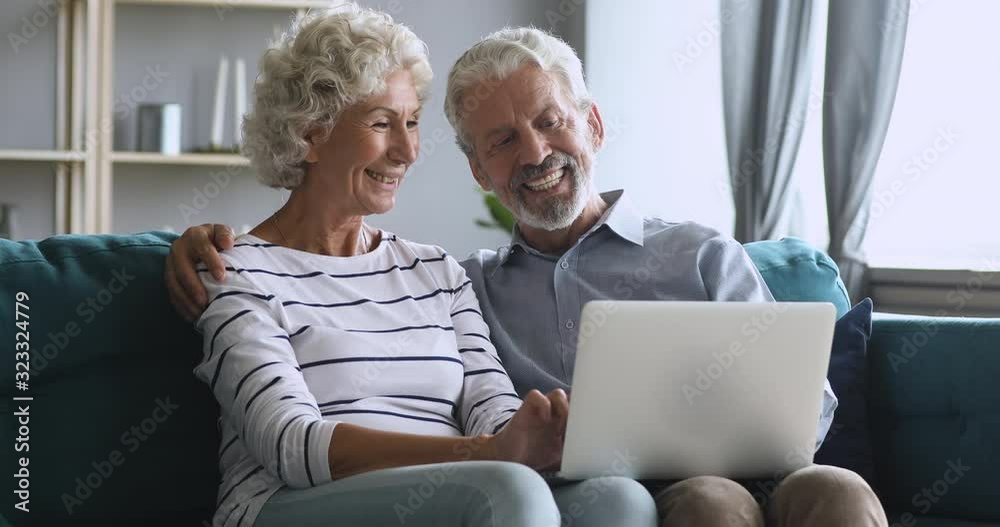 Serious middle aged man explaining new computer software to wife. Serious middle aged man explaining new computer software to wife.