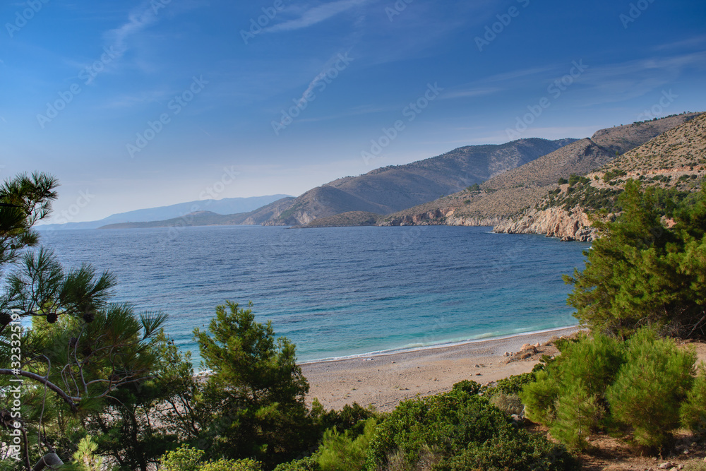 Seawater surface view horizon and the green pine trees with the mountains view on background, Greece paradise island Chios beach