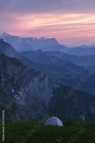 summer camping on a background of rocky alpine mountains green grass landscape