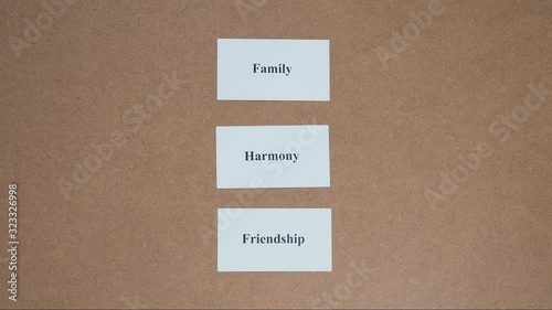 Top shot - Hand puts paper card HARMONY. CORE VALUE concept.