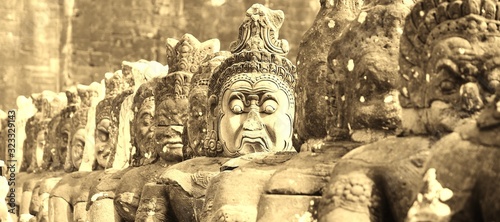 Magnificent stone figures at Angkor Thom South Gate photo