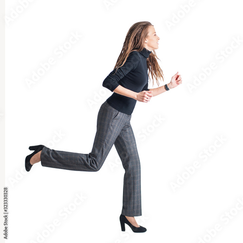 a young woman in trousers and a turtleneck is running on a white background.  business lady, business woman