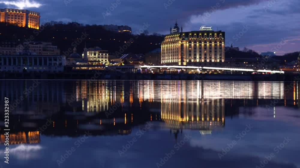 Panoramic night view of Kyiv reflecting in the waters of Dnipro river, Ukraine