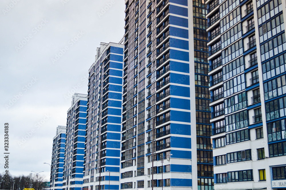 Obraz premium New modern tall blue glass multi-storey comfortable urban monolithic frame houses buildings skyscrapers new buildings in the big city of the megalopolis