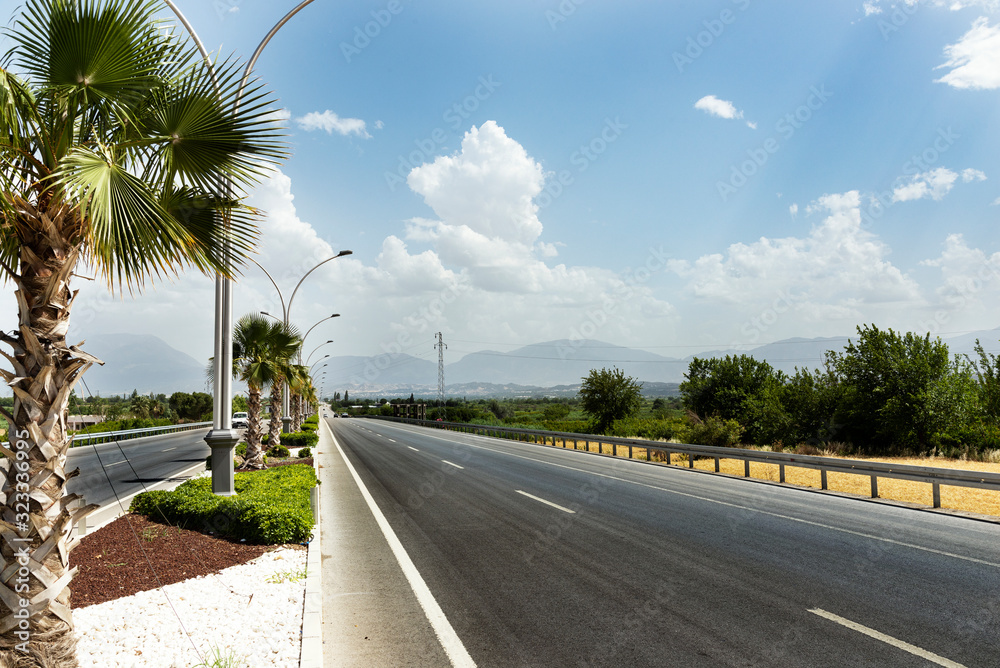 Straight road background with cloudy sky.