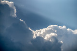 Solar beam is like a spotlight shining from behind the huge Cumulus clouds