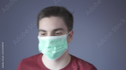 Virus infection protection measures. Young guy puts a medical mask on face. Protection from pathogenic bacteria. Corona virus and influenza viruses medical defend and epidemic precautions