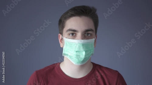 Virus infection protection measures. Young guy puts a medical mask on face. Protection from pathogenic bacteria. Corona virus and influenza viruses medical defend and epidemic precautions