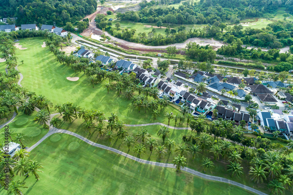 Aerial view drone Top down shot of beautiful green golf field with modern villa High angle view in summer time.