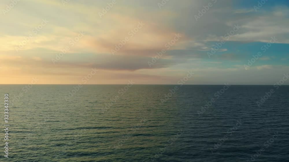 A drone flies forward low above the water at sunset or sunrise. Dramatic clouds above the surface of the sea or ocean. The calm expanse of the sea in the evening with beautiful clouds. A drone flies forward low above the water at sunset or sunrise. Dramatic clouds above the surface of the sea or ocean. The calm expanse of the sea in the evening with beautiful clouds.