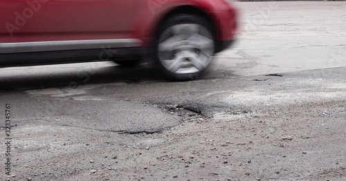 Obraz na płótnie The car goes around a pothole on the road