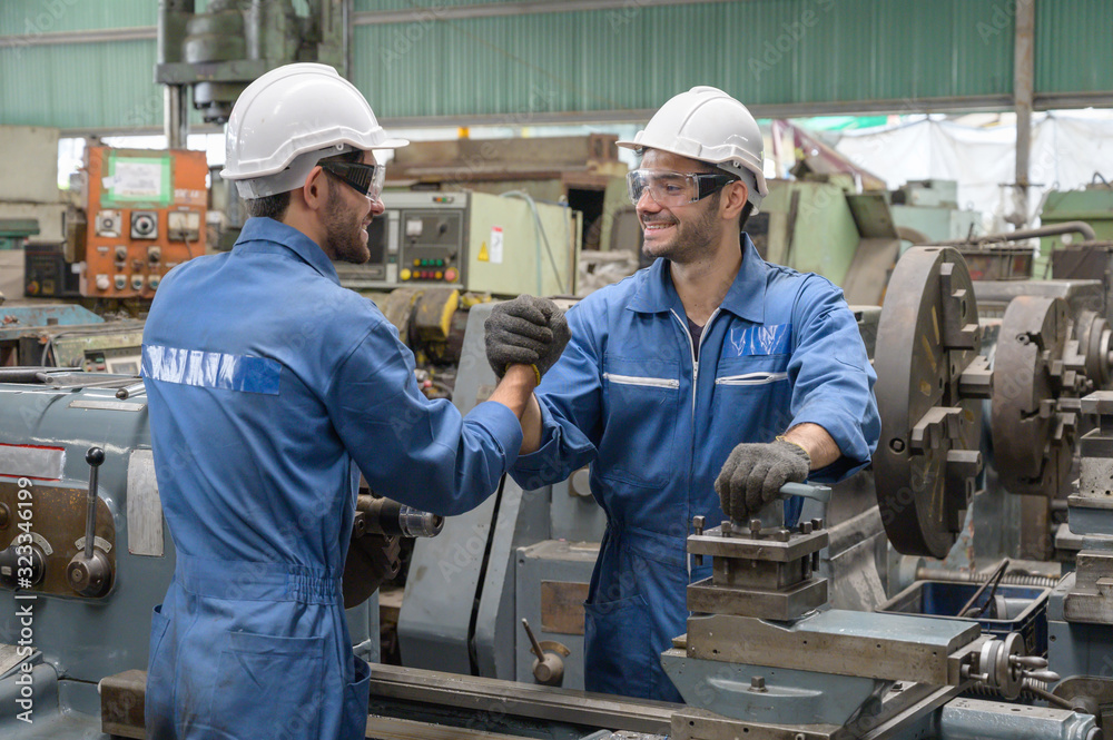 Two Caucasian male worker engineer handshakeing in the production line process in factory Two Caucasian male worker engineer handshakeing in the production line process in factory