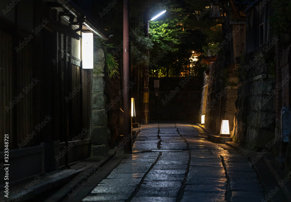 Lamps illuminate quiet alleyway through historic Kyoto neighborhood