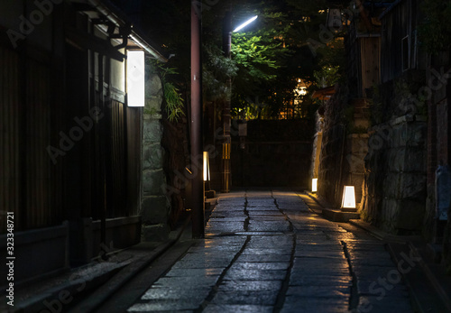 Lamps illuminate quiet alleyway through historic Kyoto neighborhood