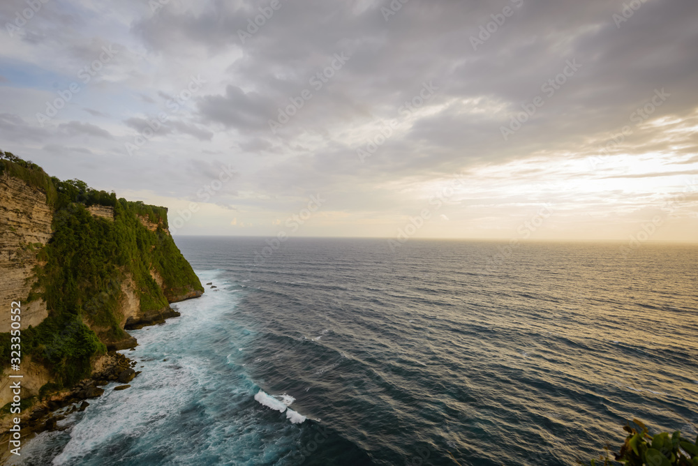 A view of Idian Ocean from Bali, Indonesia. Beautiful blue ocean water and a hanging cliff by the sea A view of Idian Ocean from Bali, Indonesia. Beautiful blue ocean water and a hanging cliff by the sea