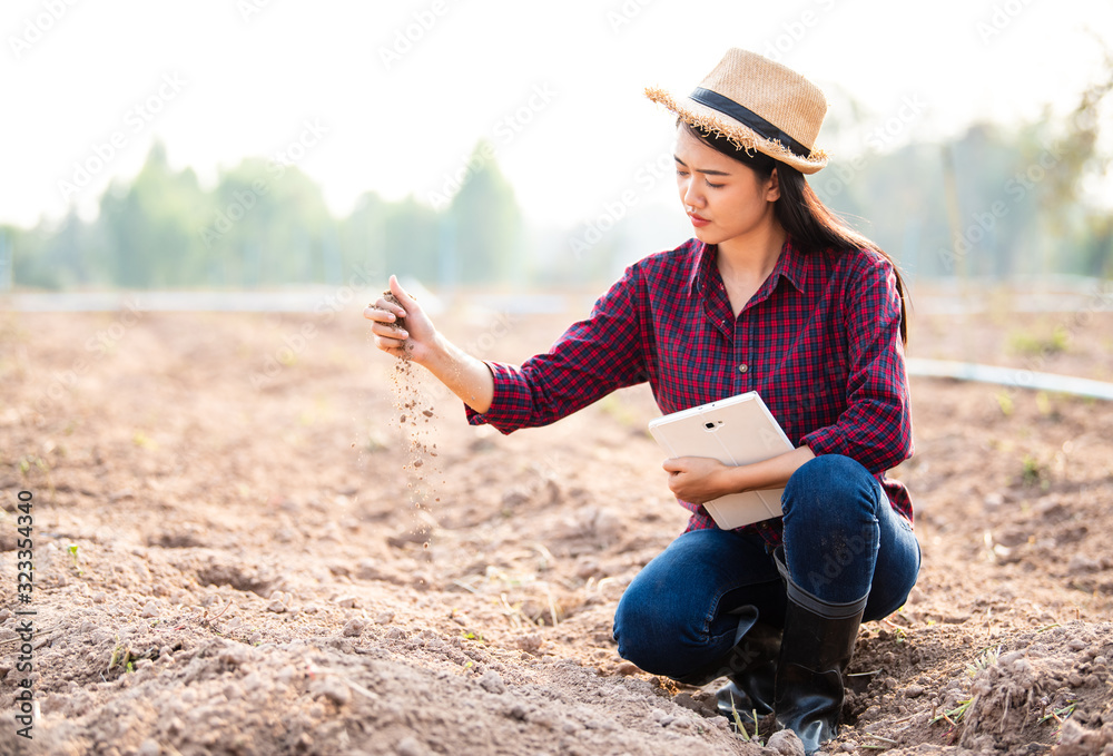 Young Asian  woman farmers are checking soil conditions to prepare to plant crops in the upcoming season.