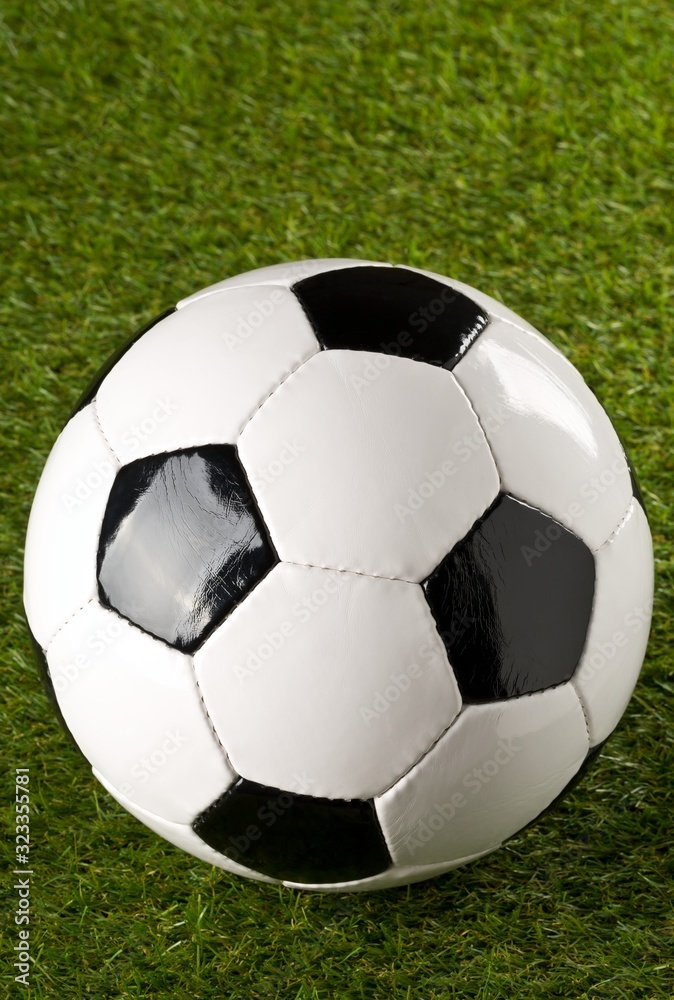 Fototapeta premium Single soccer ball on green grass lawn background with copy space